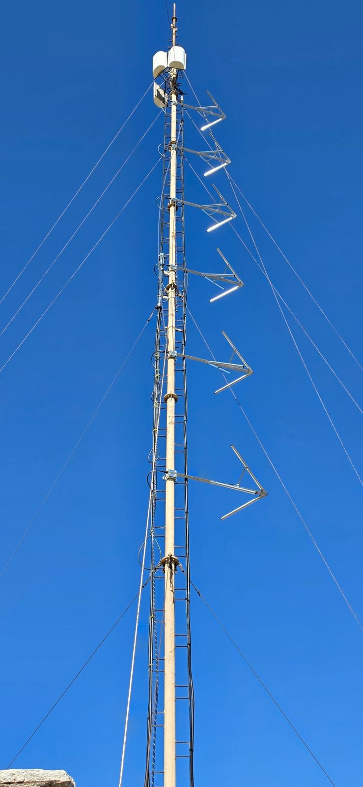 The new RadioActive 91.3 FM antenna array of six circularly polarized antennas on the mast at Artemonas, Sifnos, against a clear blue sky